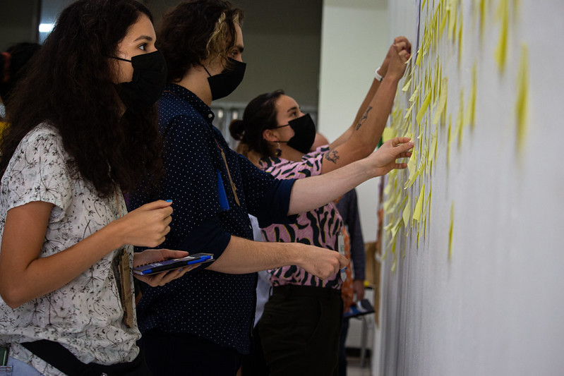 Photo of attendees placing sticky notes onto a wall at GOSH 2022