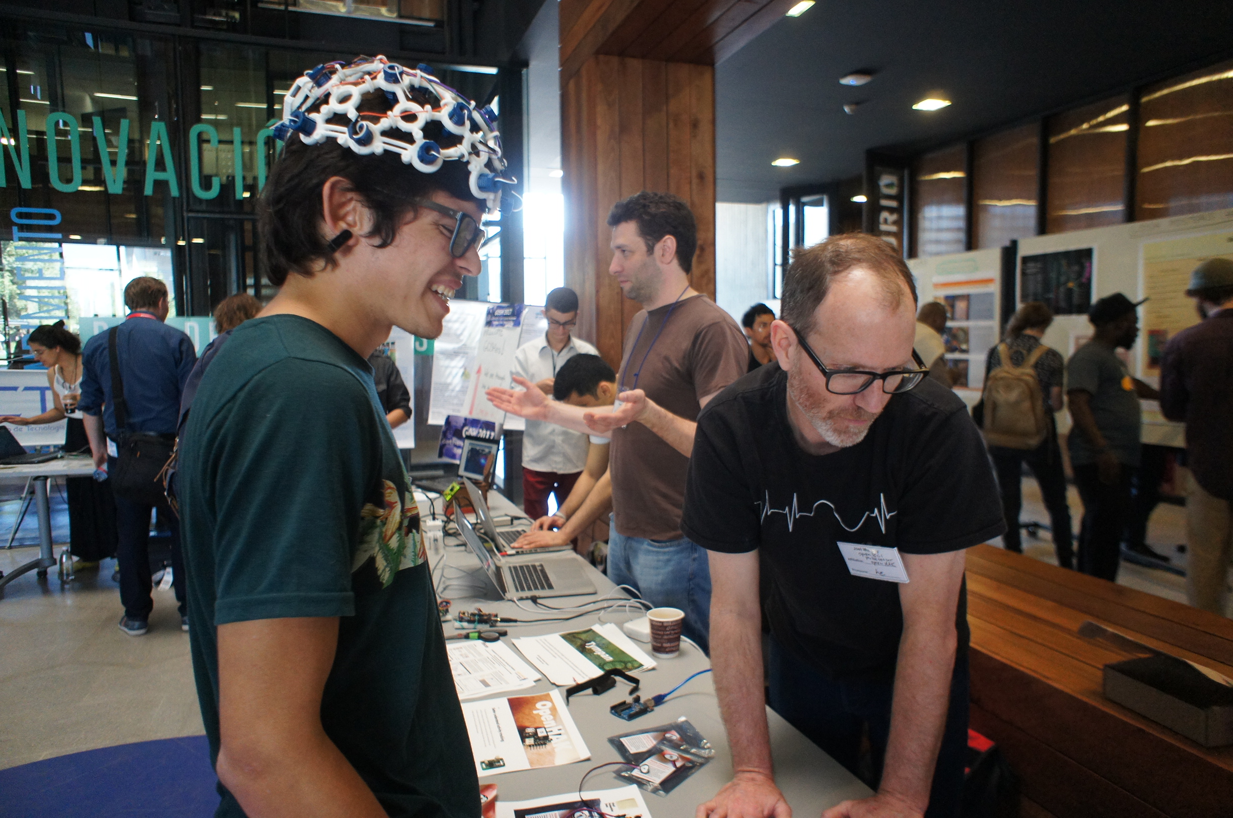 Photo of attendee at a booth at the 2017 Gathering in Santiago. The attendee wears some sort of hardware equipment on their head!