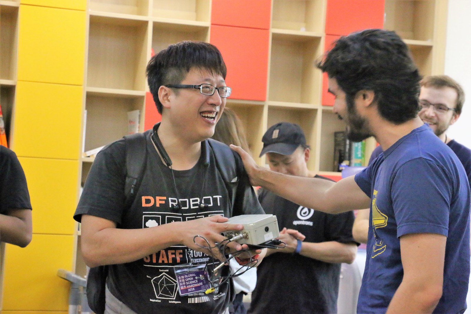 Photo of attendees sharing hardware equipment and smiling